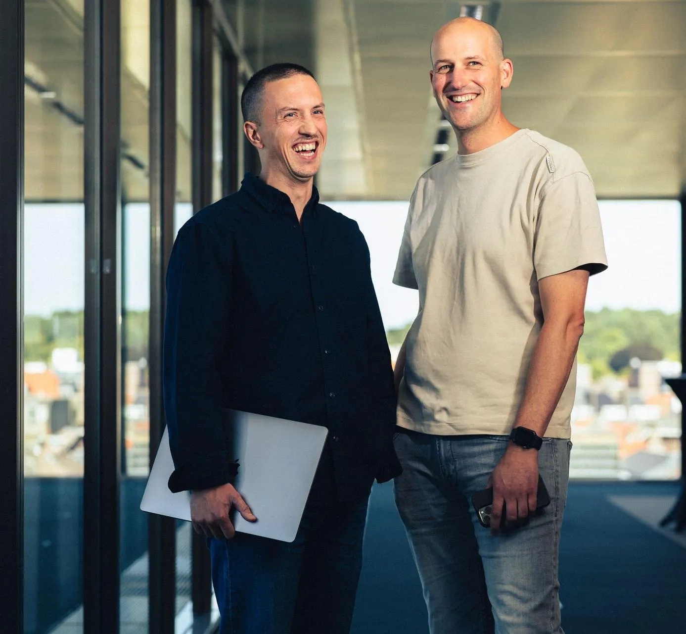 Twee Codeforward-collega's lachen samen bij het raam